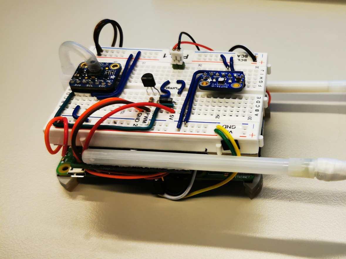 Early breadboard gas-sensing prototype with sensor modules, tubing and a single-board computer